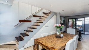 Una cocina moderna con una isla grande, armarios blancos y vistas al exterior.
