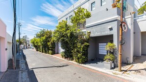 Vista de la calle con un edificio que dice 'adder street studios', con una puerta de garaje, una acera y una calle con una señal de límite de velocidad.