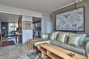 A modern living room with a sofa, coffee table, and a large map on the wall.