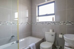Un bagno con vasca, water e lavandino.