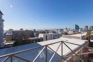 A cityscape with modern buildings, a clear sky, and a distant view of a city skyline.