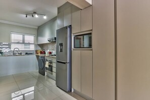 A modern kitchen with stainless steel appliances, a built-in oven, and a microwave.