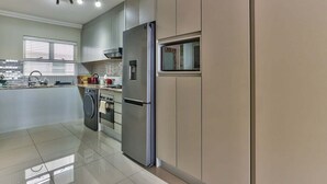 A modern kitchen with stainless steel appliances, a dishwasher, and a microwave. - Stylish 1BR Sea View Apartment near V&A by CTHA (Cape Town)