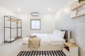 A bedroom with a bed, a wardrobe, a window, and a bedside table. - Bangkok Group Haven - 6BR Bangchak BTS 12 sleeps (Bangkok)