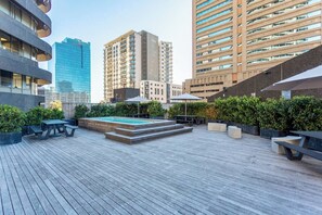 Una terrazza sul tetto con piscina, area relax all'aperto e vista sulla città.