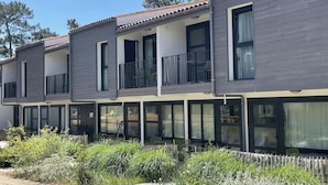 A modern multi-story residential building with balconies, large windows, and a well-maintained garden area. - Club Vacances Bleues Le Grand Air (Saint-Trojan-les-Bains)