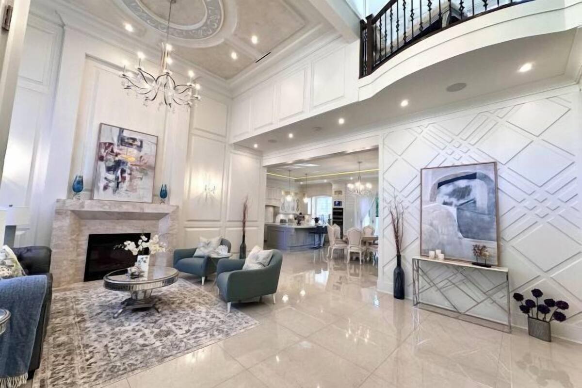 Eine großzügige Lobby mit Kamin, Sitzbereich und einer modernen Treppe.
