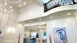A spacious interior with a high ceiling, a dining area, and a kitchen.