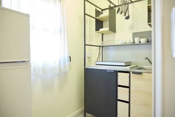 A compact kitchen with a refrigerator, a sink, and a small countertop.