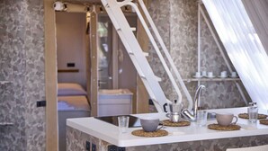 Un baño moderno con ducha, lavamanos y espejo. Incluye perchero y cortina de ducha.