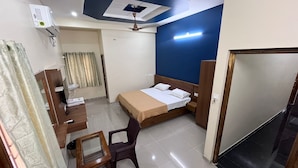 Une chambre d’hôtel équipée d’un lit, d’un bureau, d’une chaise et d’un ventilateur de plafond.