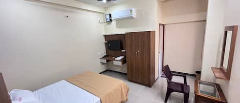 Un dormitorio con una cama, un escritorio, un armario y un ventilador de techo.