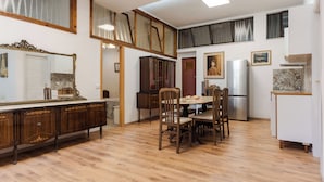 Un'ampia cucina con mobili in legno, un tavolo da pranzo con sedie e un frigorifero.