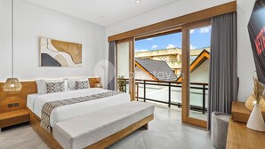 A modern bedroom with a large bed, a wooden headboard, a bedside table, and a view of a building through a glass door. - Oslen Villa by Kozystay - Canggu (Canggu)