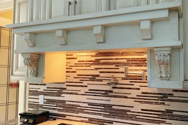 A modern bathroom with a tiled backsplash and a built-in sink.