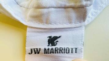 Una toalla blanca con un logotipo y texto bordados en negro que dicen 'JW MARRIOTT'.