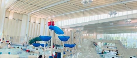 An indoor water park with multiple water slides and pools.