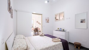 A bedroom with a bed, a desk, a chair, and a small stool. - Apartment 'Casa Vacanze Lu Rizzaru' with Private Terrace, Balcony & Air Conditioning (Nardò)