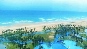 Een resort met uitzicht op het strand, slingerende paden en meerdere zwembaden.