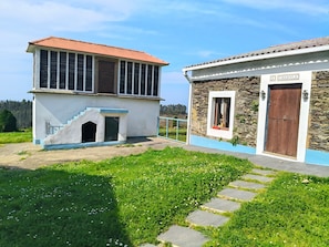 Un edificio con fachada de piedra, una puerta de madera y una ventana en un muro de piedra.