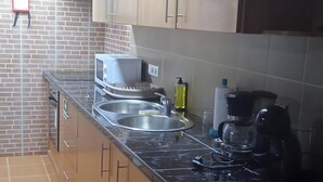 A kitchen with a sink, stove, and cabinets. - Holiday Home 'Do Avô Almeida' with Mountain View, Balcony and Wi-Fi (Lajes das Flores)