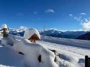 A snow-covered wooden structure with a clear view of snow-covered mountains in the background. - Unique Alpine Pasture in the Zillertal Mountains (Zellberg)