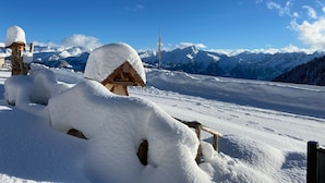 A snow-covered wooden structure with a clear view of snow-capped mountains in the background. - Unique Alpine Pasture in the Zillertal Mountains (Zellberg)