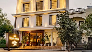 Un hotel de varios pisos con una entrada destacada, ventanas amplias y un letrero que indica un área de lounge.