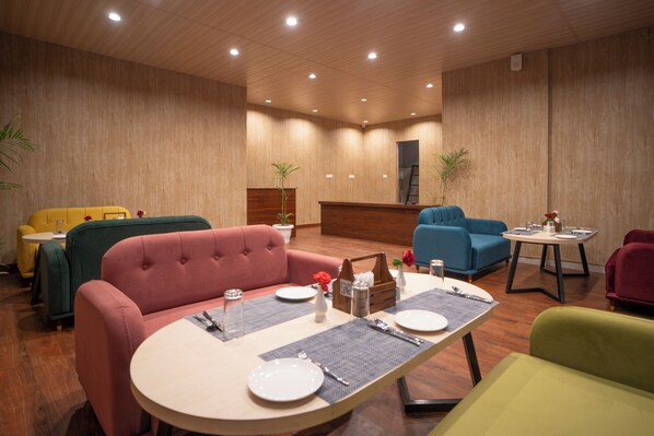 Un espace repas doté d’un plafond en bois, de sièges rembourrés et d’un comptoir d’accueil.