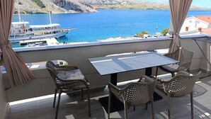 Un balcone con tavolo e sedie che si affaccia su un'area d'acqua con barche.