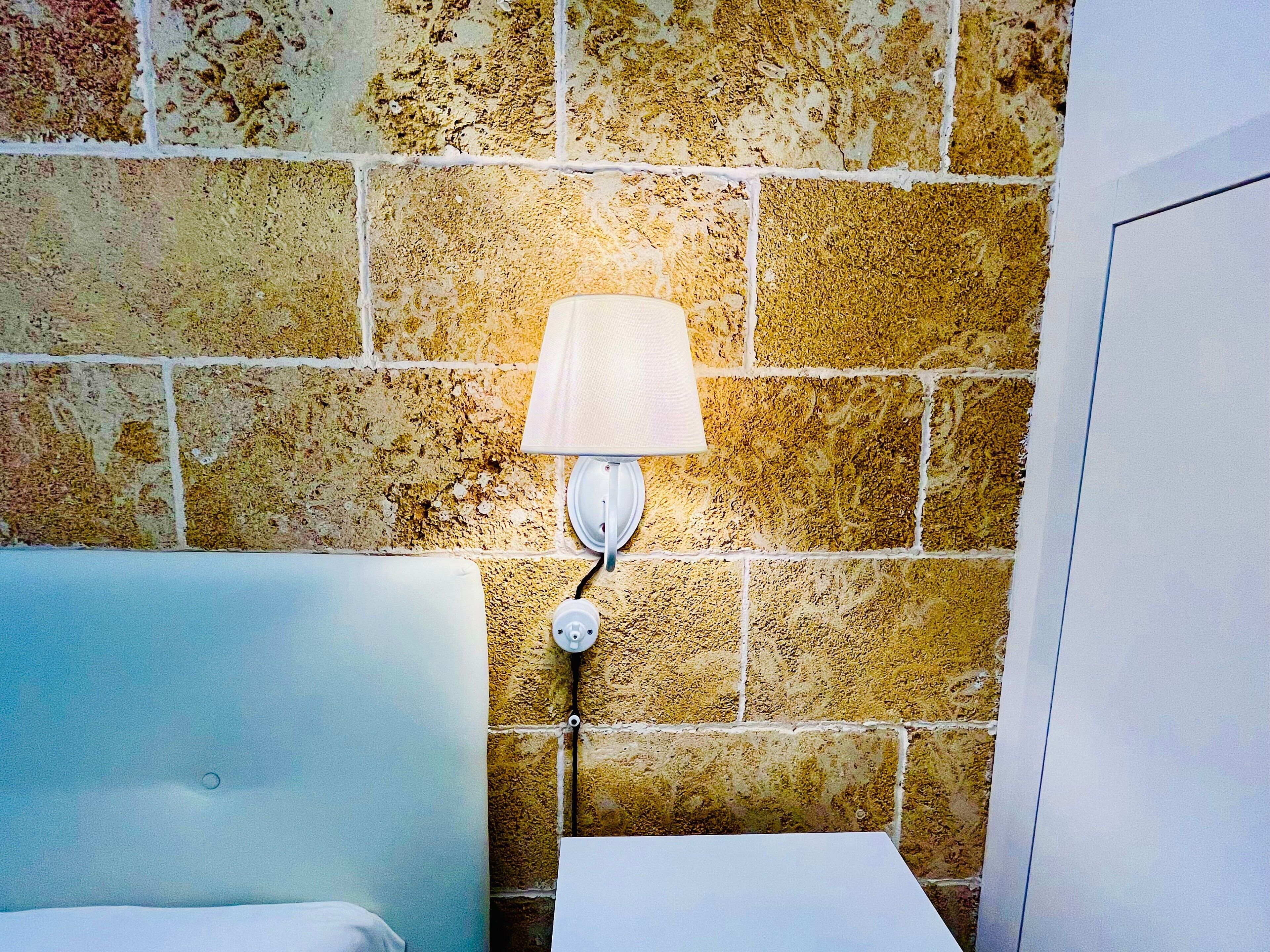 Ein Badezimmer mit einer weißen Badewanne, einem weißen Waschbecken und einer wandmontierten Leuchte.