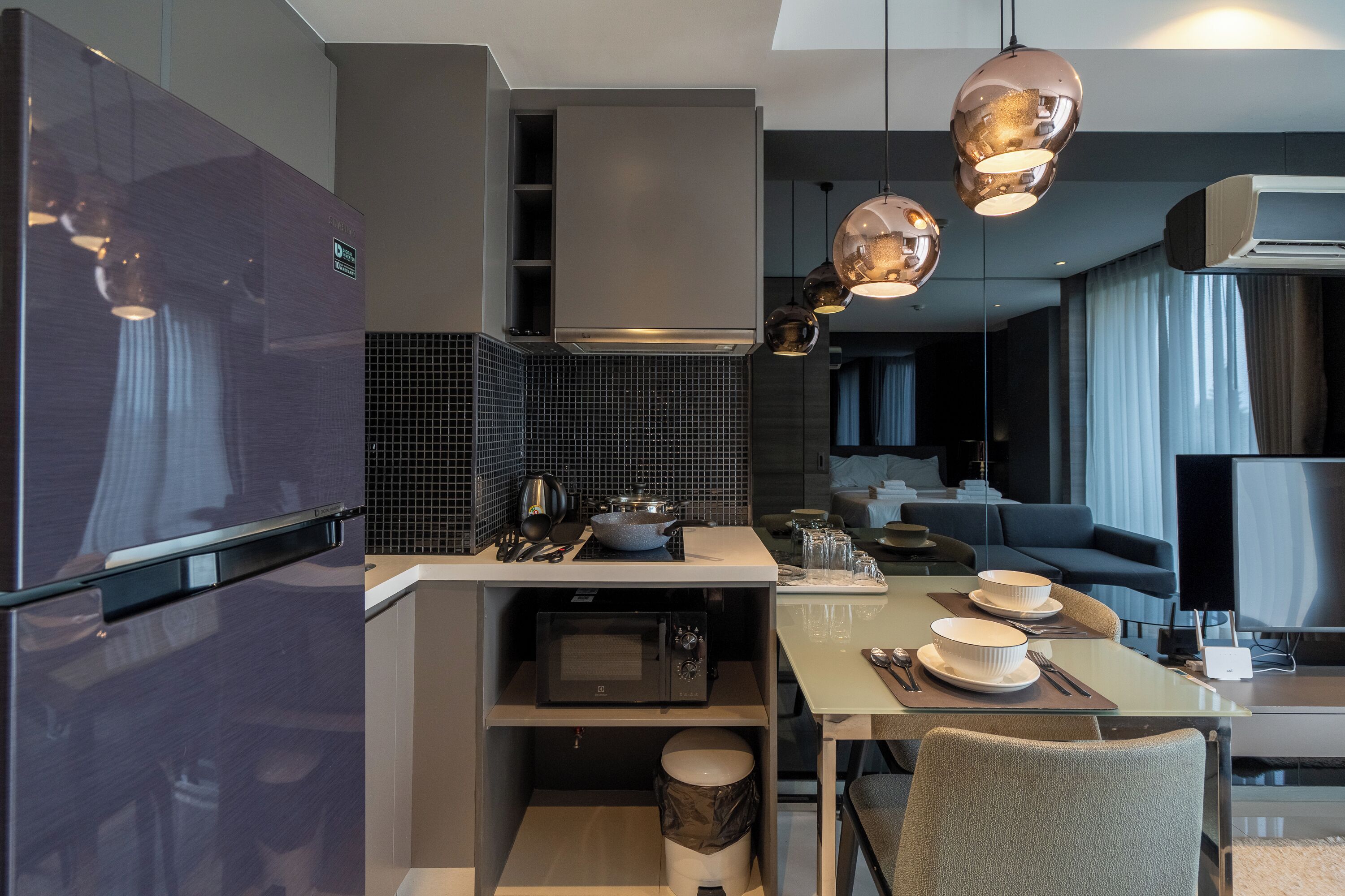 A modern kitchen with a built-in microwave, a gas stove, and a sink. There is a dining area with a table and chairs.