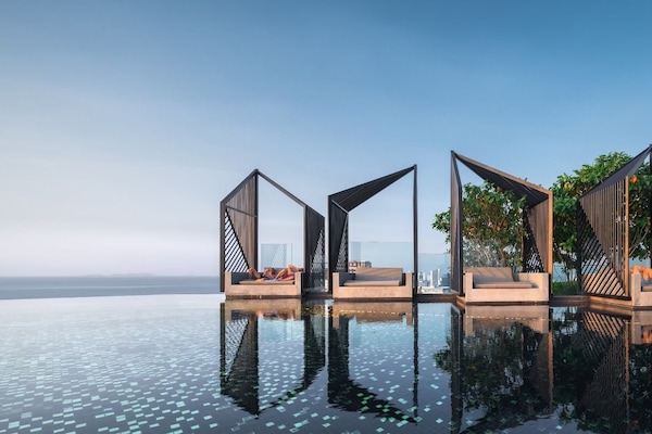 Una piscina al aire libre, sillones reclinables de piscina