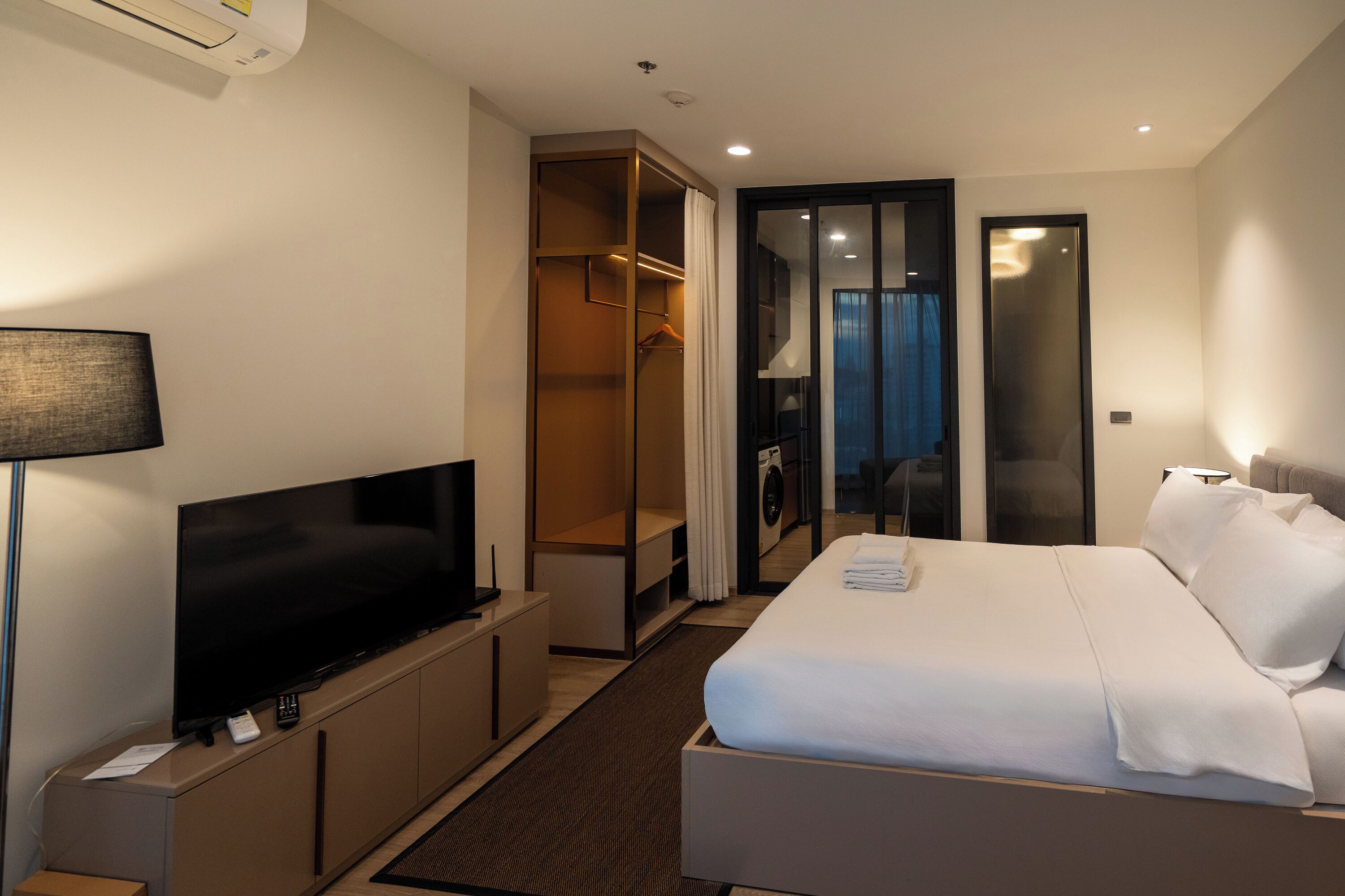 Een hotelkamer met een bed, een televisie, een kast en een badkamer.