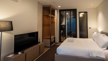 Een hotelkamer met een bed, een televisie, een kast en een badkamer.