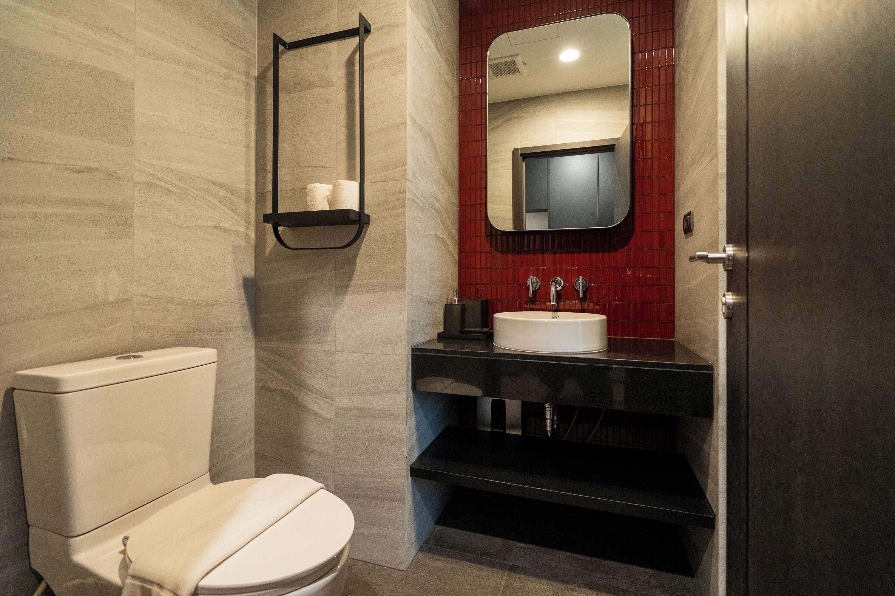 Un bany modern amb vàter, un lavabo i un mirall.