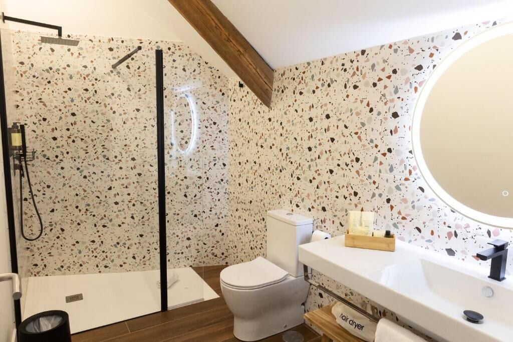 Une salle de bain avec douche, toilettes et lavabo.