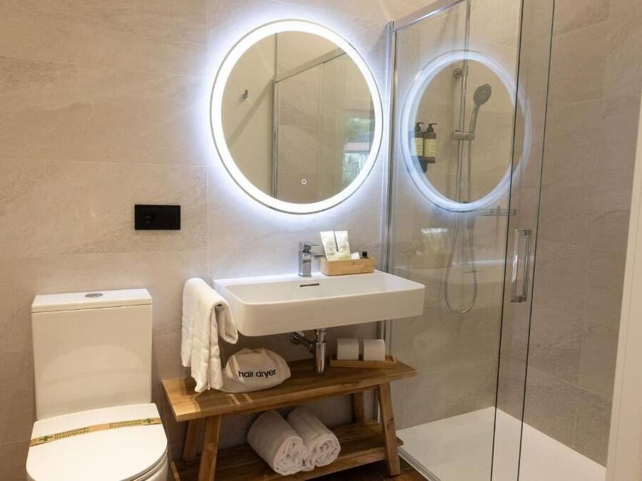 Uma casa de banho moderna com sanita, lavatório e cabine de chuveiro com vidro.