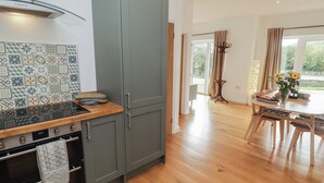 A modern kitchen with grey cabinets, a tiled backsplash, and a wooden countertop. - The Lodge (Bridgend)
