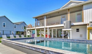 A modern two-story house with a large swimming pool, a covered outdoor area, and a visible staircase.