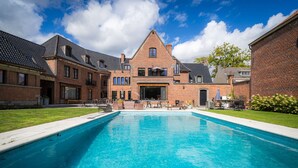Une piscine avec un bâtiment en briques en arrière-plan.