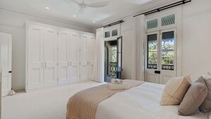 A bedroom with a large bed, a ceiling fan, and a view of the outdoors through a window. - The Newtown Haven with Private Parking (Newtown)