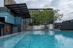 Een buitenzwembad, parasols voor strand/zwembad