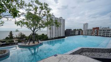 Una piscina al aire libre, sombrillas, tumbonas