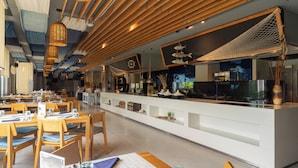 A modern restaurant with wooden ceiling slats, hanging wicker lamps, and a central counter with seafood-themed decorations. - Oceanphere Villa by Prop Hopper (Sattahip)