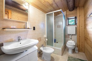 Un baño con lavamanos, inodoro y ducha.