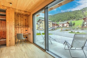 Una habitación con paredes de madera, un ventanal grande, un escritorio y dos sillas.