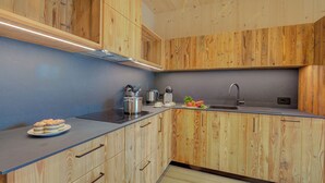 A modern kitchen with wooden cabinetry, a grey countertop, and a sink. - Leba 3 (Livigno)