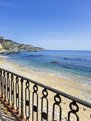 A coastal beach with a metal railing, clear blue water, and rocky cliffs in the background. - Vigna dell`Etna - Piedimonte Etneo (Piedimonte Etneo)