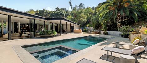 Una piscina al aire libre, tumbonas